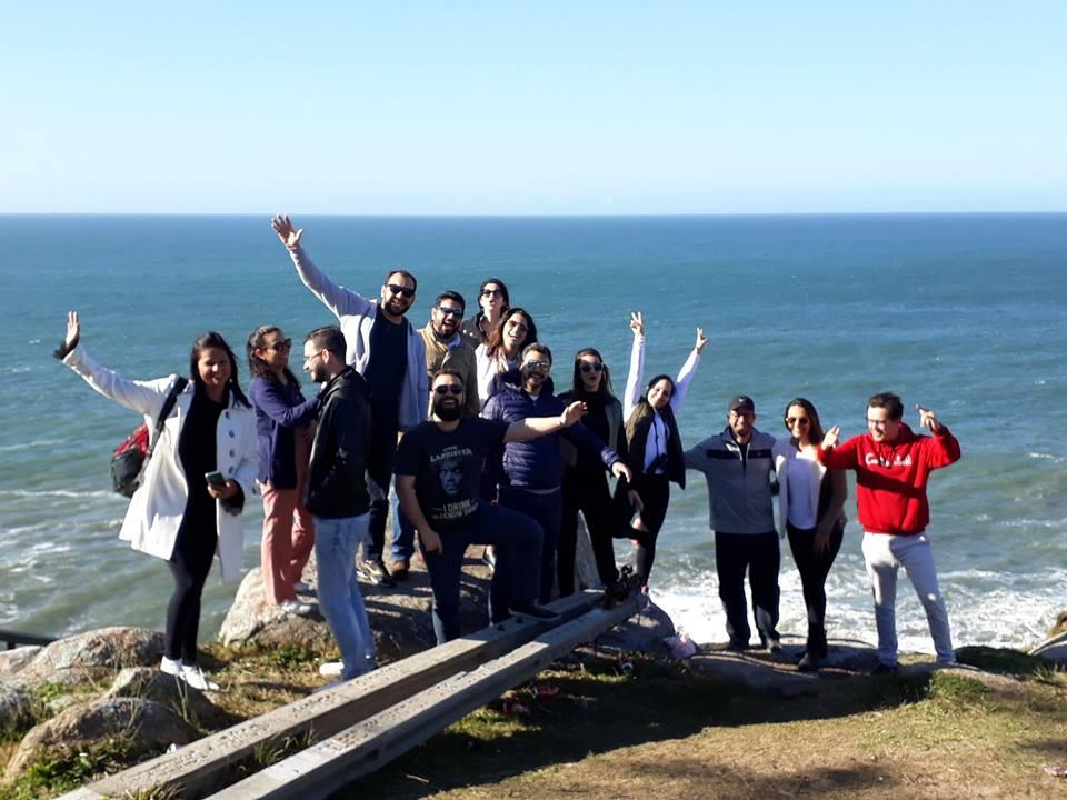 Rodney com um grupo comemorando à beira-mar, de braços erguidos